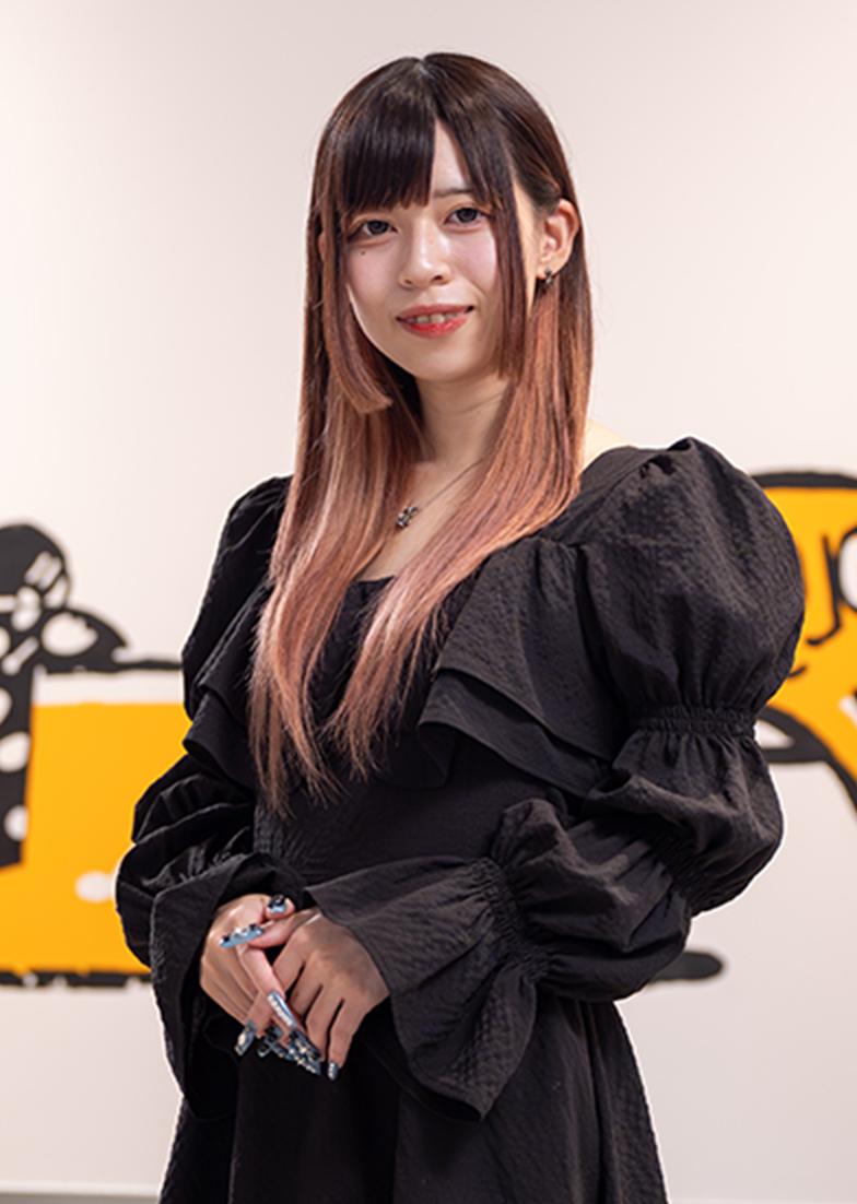 手を前で組み微笑んで立っている写真